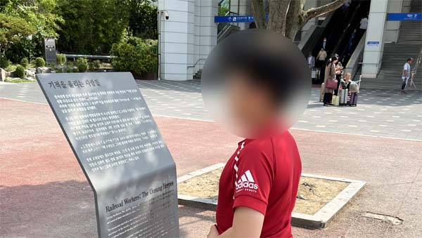 삽을 든 사람들의 동상 기록을 보는 아들